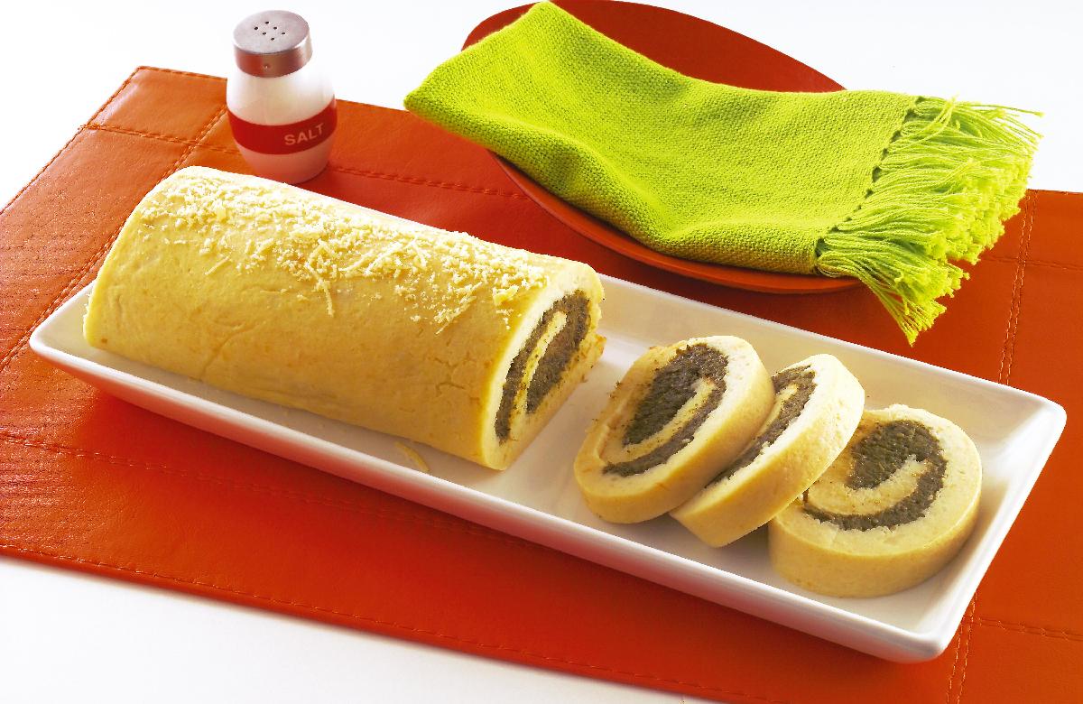 Prato colorido com folhas verdes, legumes e preparação caseira.